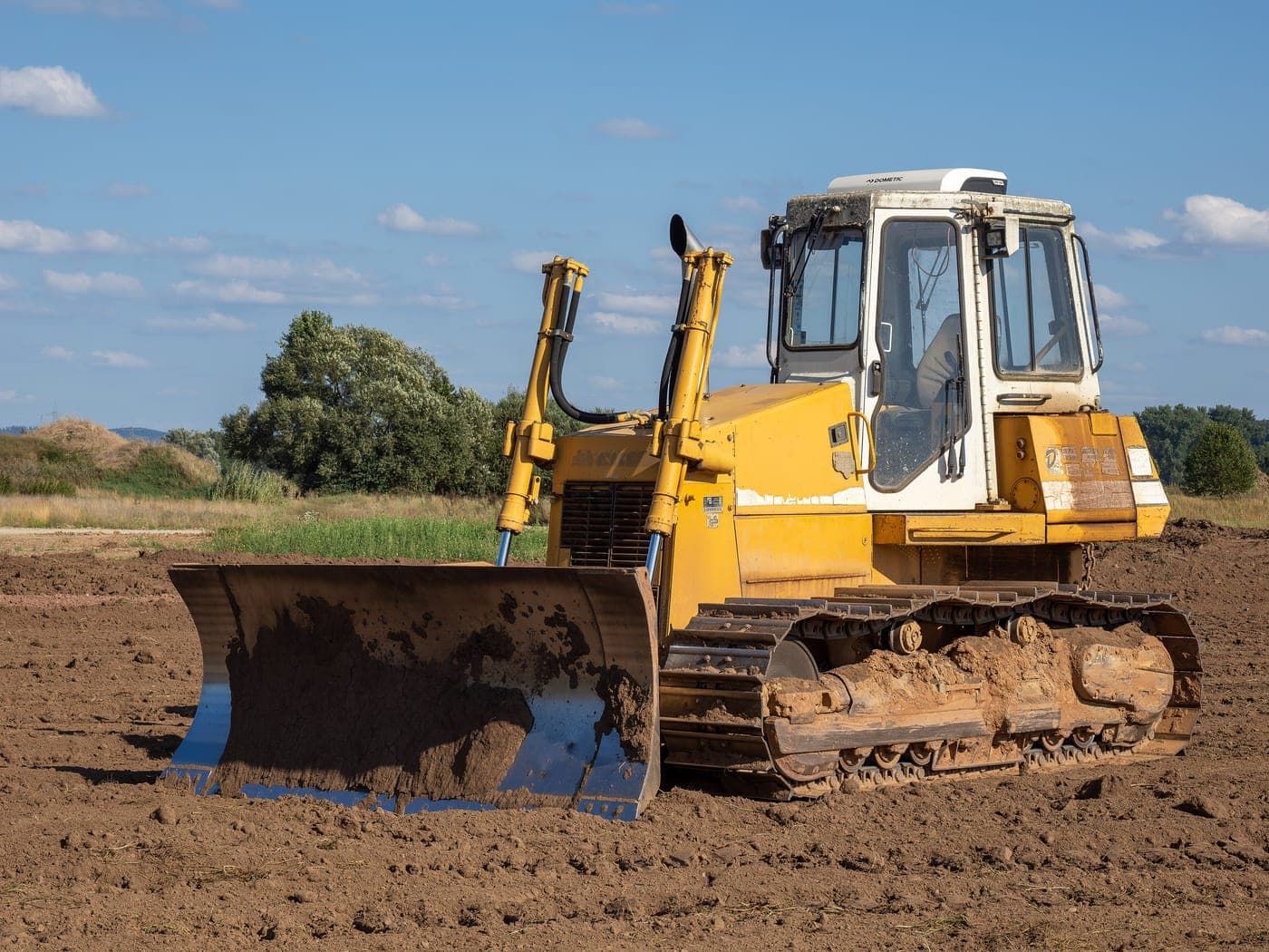 Crawler bulldozer with front blade on a dirt site