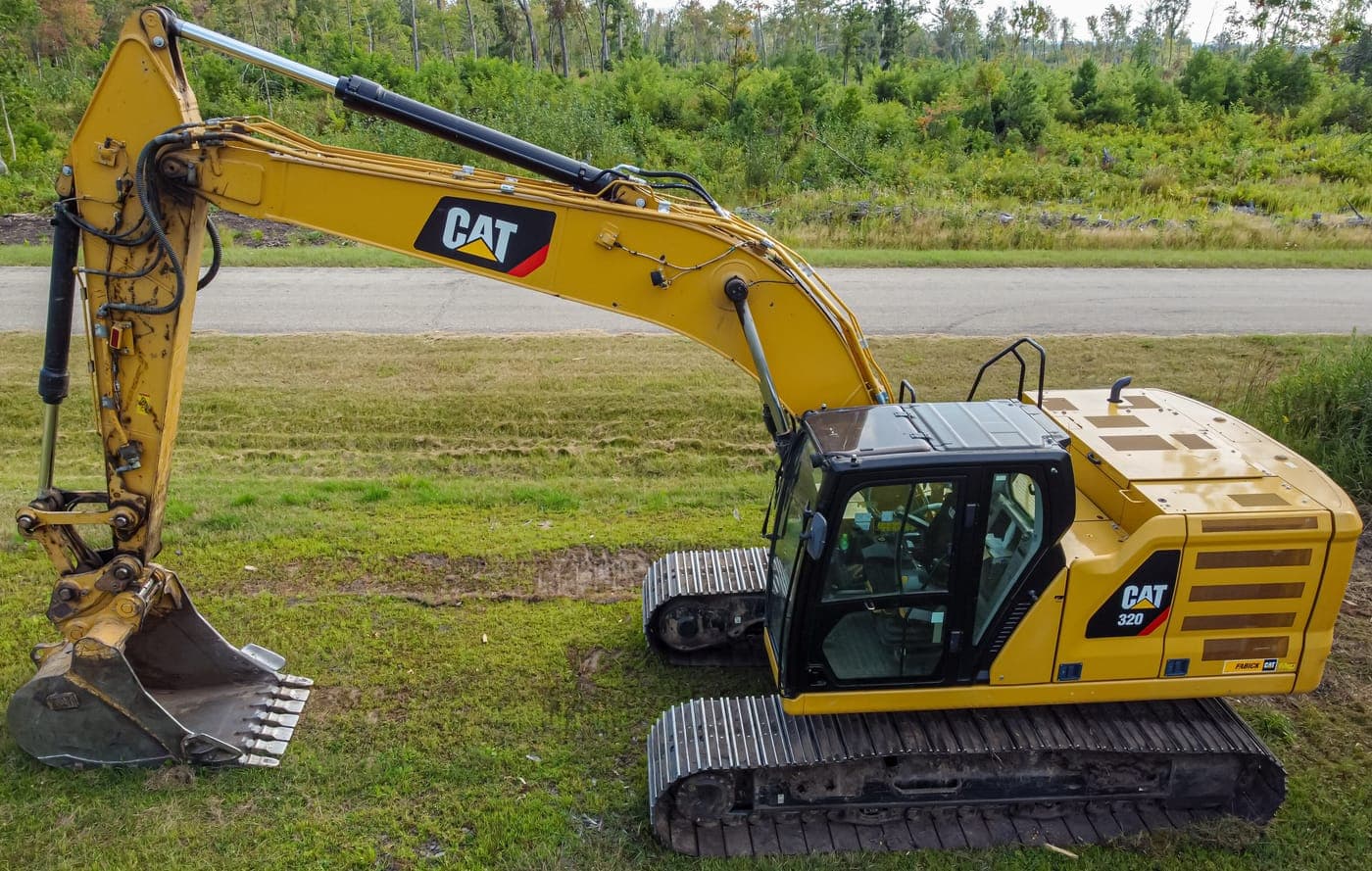 Crawler excavator parked on grass, side view