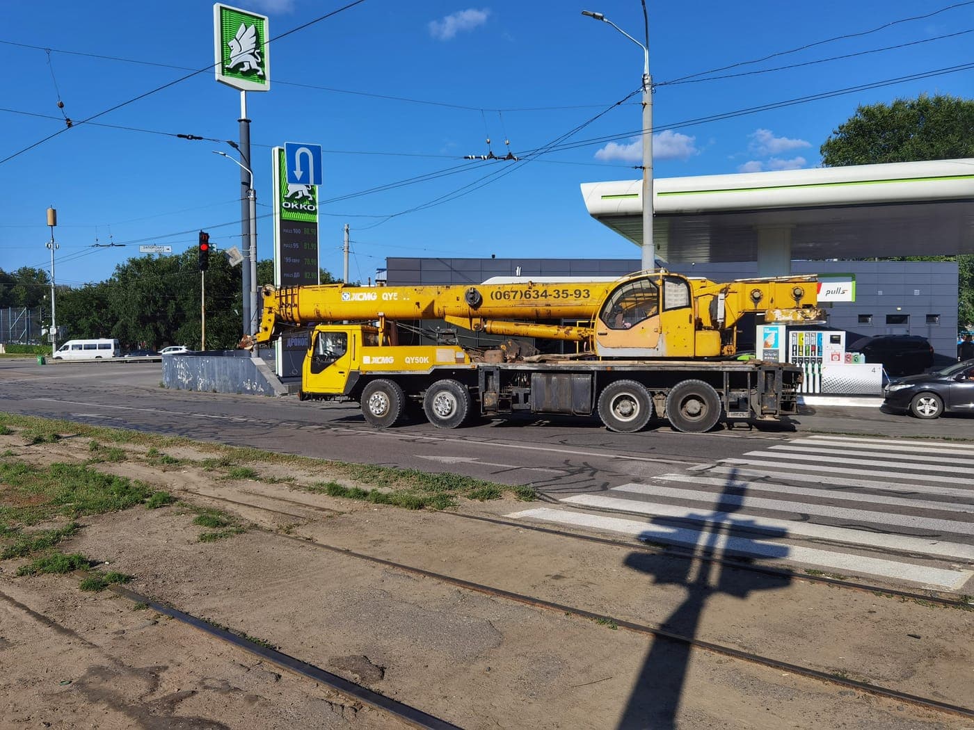 Yellow truck crane parked on a wide road