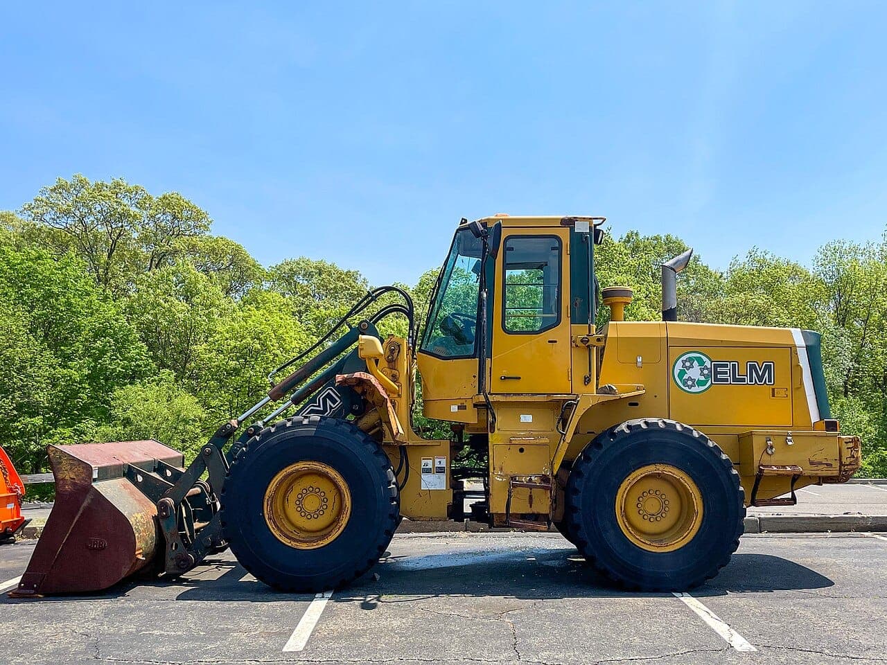 Yellow wheel loader parked in a car park